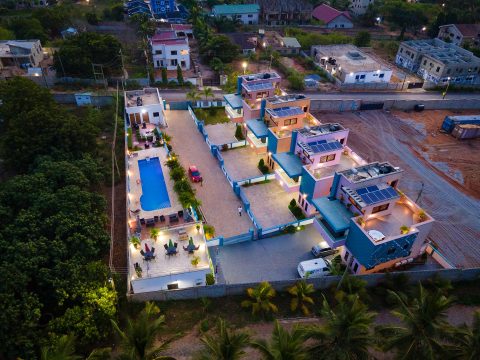 Aerial view of the residence at dusk with the pool and terraces lit
