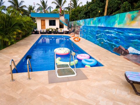 Swimming pool beside a hand-painted ocean mural wall