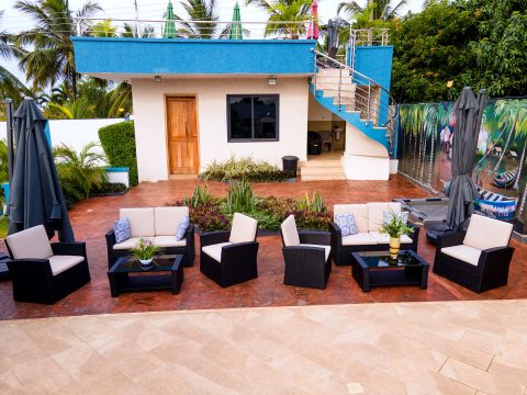 Outdoor lounge with wicker sofas beside the pool house