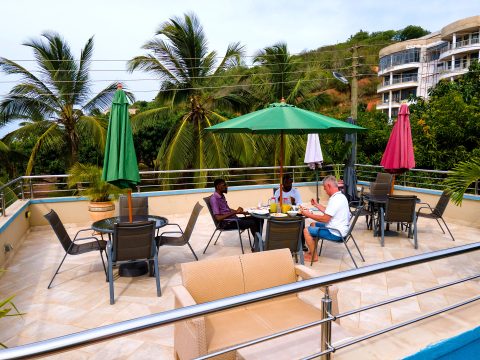 Guests dining on the rooftop terrace under parasols