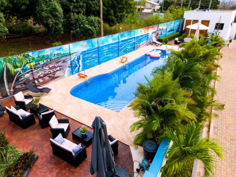 Pool and outdoor lounge seating framed by palms