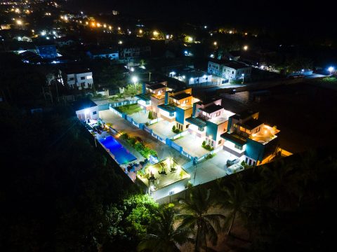 The residence lit up at night among the lights of Kokrobite