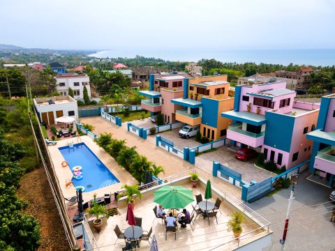 Aerial view of the pool, rooftop dining terrace and the three colourful apartment buildings
