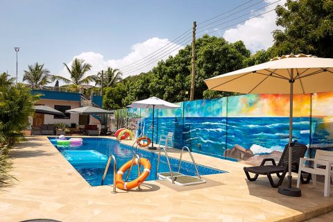 Poolside loungers and parasols along the painted mural wall