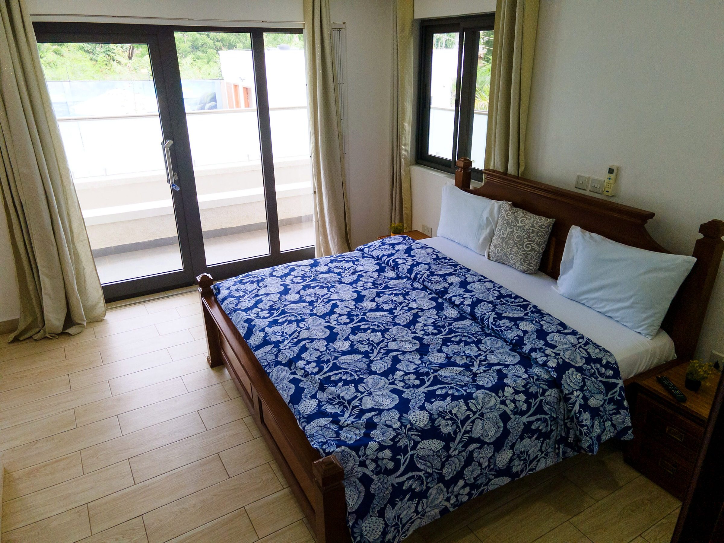 Brown apartment bedroom with a double bed and sliding doors to a balcony