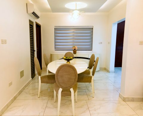 Brown apartment dining room with an oval table and upholstered chairs