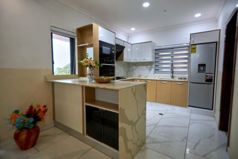 Pink apartment fitted kitchen with breakfast counter and fridge