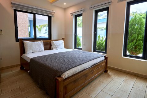 Pink apartment bedroom with a double bed and garden-facing windows