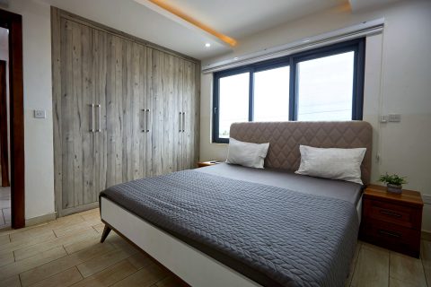 Pink apartment bedroom with an upholstered bed and full-height wardrobe