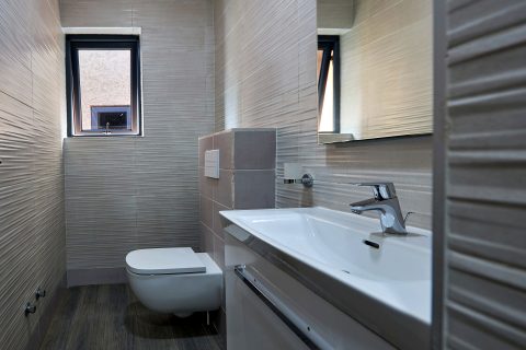 Pink apartment bathroom with a textured tile wall