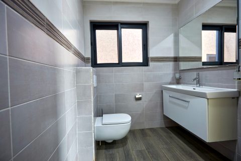 Pink apartment bathroom with vanity and wall-hung toilet