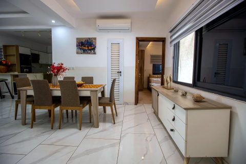 Orange apartment dining table beside a sideboard