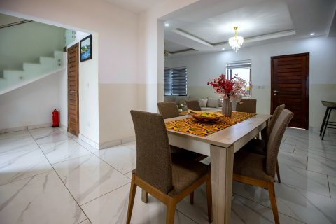 Orange apartment dining area with the staircase and living room beyond