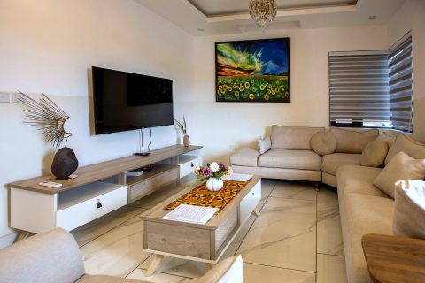 Orange apartment living room with a corner sofa and TV unit