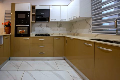 Orange apartment fitted kitchen with built-in oven and microwave